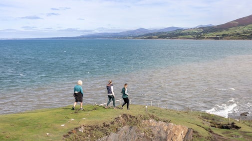 Walkers on the coastal path on Llyn Peninsula at Morfa and Nant Bach, Gwynedd